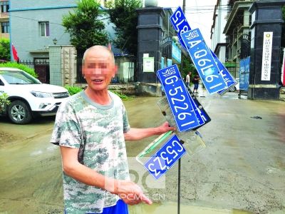 武汉大雨后七旬老人在齐腰深水中捞车牌赚钱(图)